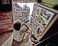 girl sitting in front of fridge